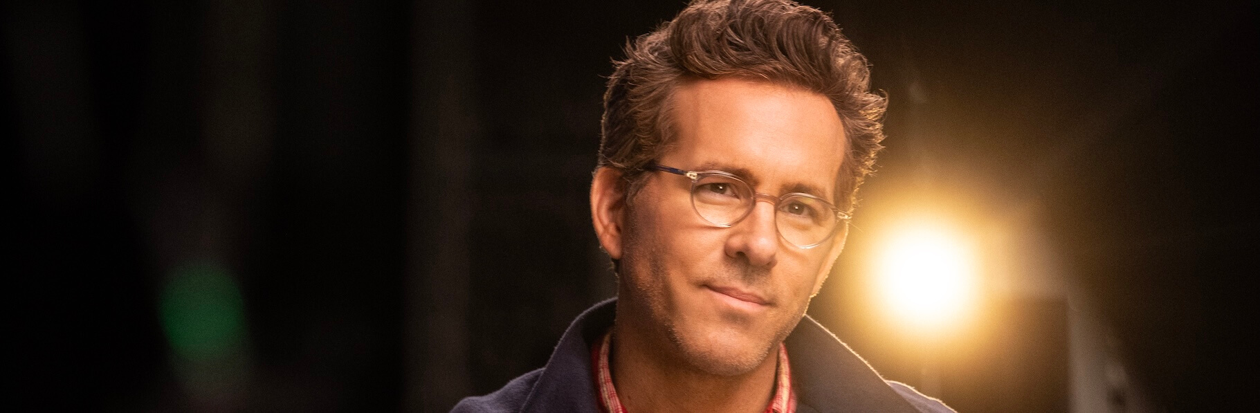 Ryan Reynolds sitting in a chair during an interview